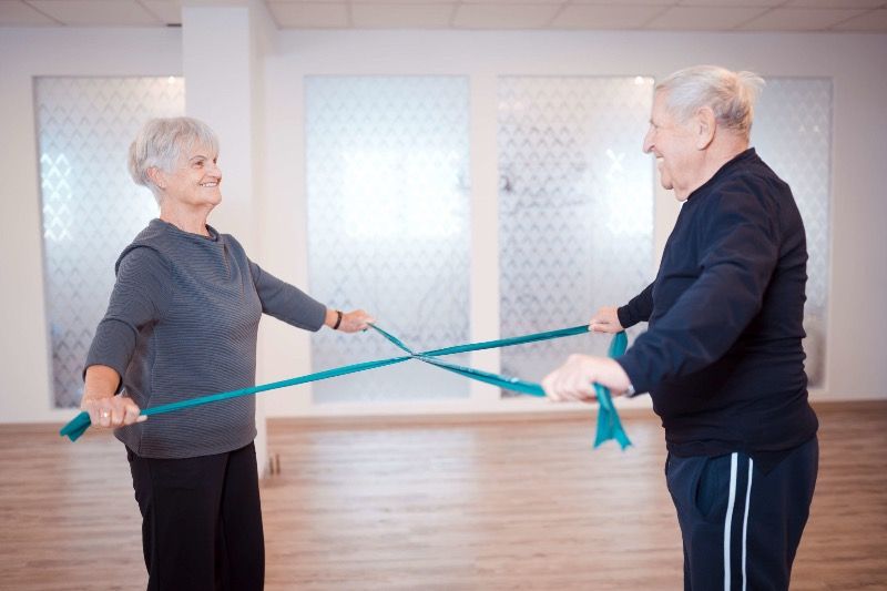 Foto: In einer Düne nahe des Meeres sitzt eine junge Frau gelassen auf ihrer Yogamatte. Sie kommt zur Ruhe ohne einzuschlafen.